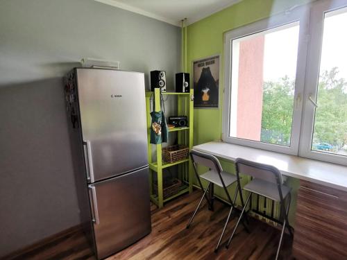 a kitchen with a refrigerator and a table and chairs at Kwadrat Maja in Wałbrzych