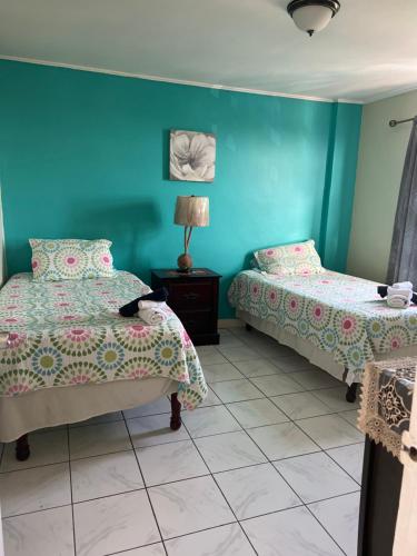 2 camas en una habitación con paredes azules en The Dorchester, en Kingston