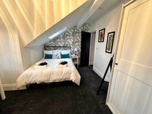 a bedroom with a bed with two pillows on it at 3a Roman View, beautifully appointed apartment in Roundhay, sleeps up to 6, bedrooms with en suite bathrooms, EV charging in Moortown
