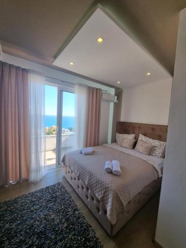 a bedroom with a bed with two white towels on it at Kahari Apartments in Ulcinj