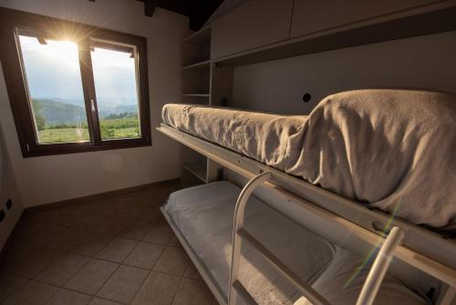 a bunk bed in a room with a window at Il Casot Private House with Pool in Borgomale