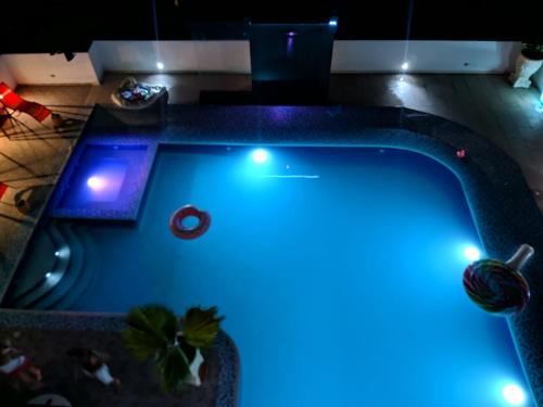 a swimming pool with blue lights in a room at Villa campestre Casa Blanca Full House in Agua de Dios