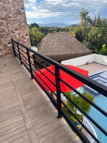 a balcony with a red bench on a house at Villa campestre Casa Blanca Full House in Agua de Dios