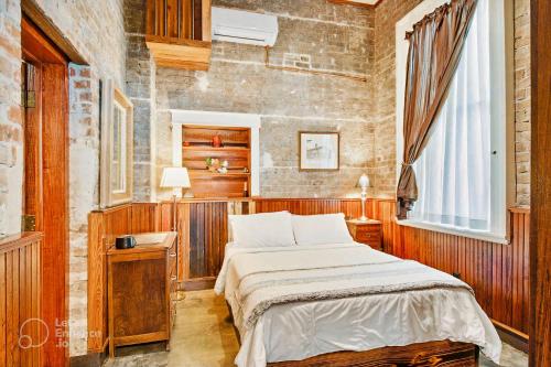 a bedroom with a bed and a brick wall at Inn at the Old Jail in New Orleans