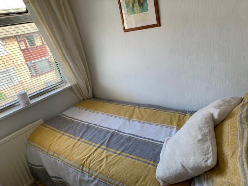 a small bedroom with a bed and a window at Hadfield Avenue in Hoylake