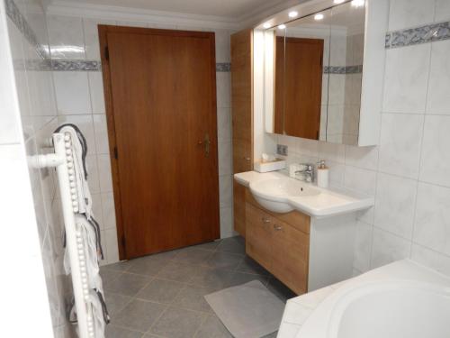 een badkamer met een wastafel, een toilet en een spiegel bij Landhaus Gollner in Uderns
