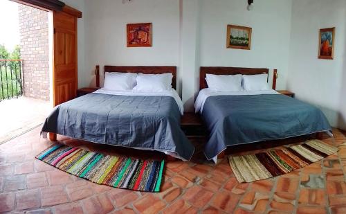 dos camas sentadas una al lado de la otra en una habitación en Color Marron casa de campo en Barichara