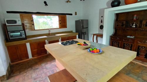 una cocina con una mesa con un bol de fruta. en Color Marron casa de campo en Barichara
