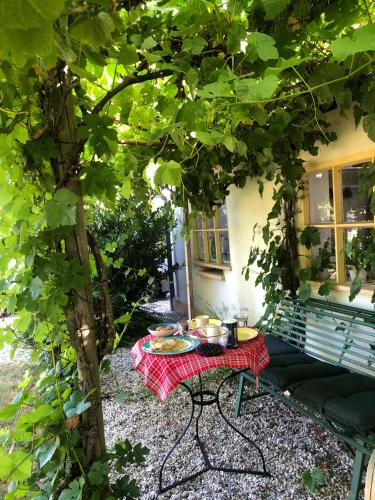a picnic table under a tree in front of a house at Het Betuws Erfje in Maurik