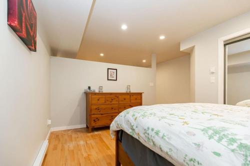 ein Schlafzimmer mit einem Bett und einer Holzkommode in der Unterkunft Lovely 1 Bedroom Suite Near Town in Victoria