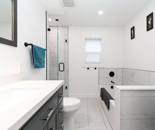 a white bathroom with a toilet and a glass shower at Lovely 1 Bedroom Suite Near Town in Victoria