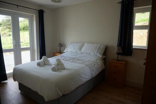 a bedroom with a bed with two stuffed animals on it at Sally's in Mullanmore
