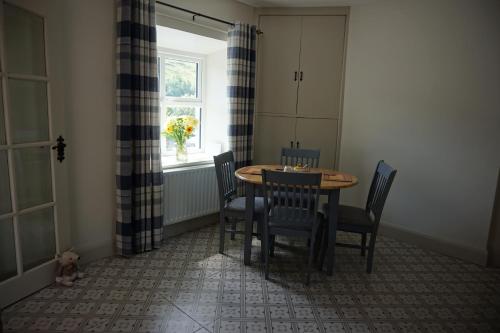 a dining room with a table and chairs and a window at Sally's in Mullanmore