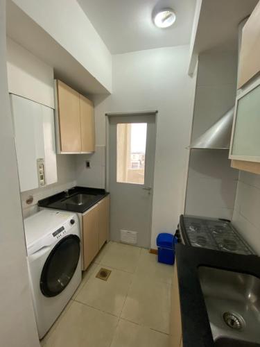 a small kitchen with a washing machine and a sink at Efimero San Juan, pleno centro in San Juan