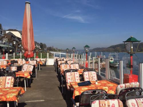 a row of tables and chairs with umbrellas on a pier at Hotel Rheinischer Hof in Bad Breisig