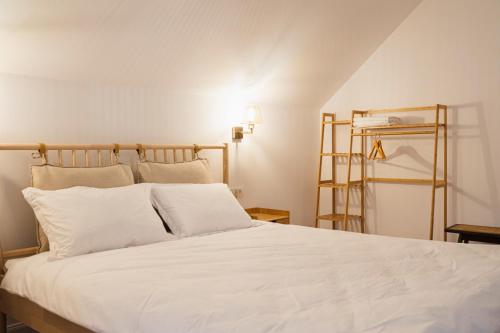 - une chambre avec un lit blanc et des oreillers blancs dans l'établissement Orastioara Retreat, 