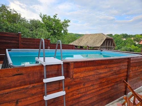 a swimming pool with a wooden fence and stairs next to it at Dvokrevetne Sobe - Snežana in Ležimir