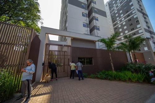 eine Gruppe von Menschen, die vor einem Gebäude mit einem Hund stehen in der Unterkunft Apartamento confortável próximo ao Transamérica Expo in São Paulo