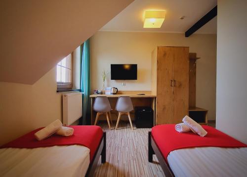 a room with two beds and a desk with a computer at Gościniec Konopielka in Zblewo