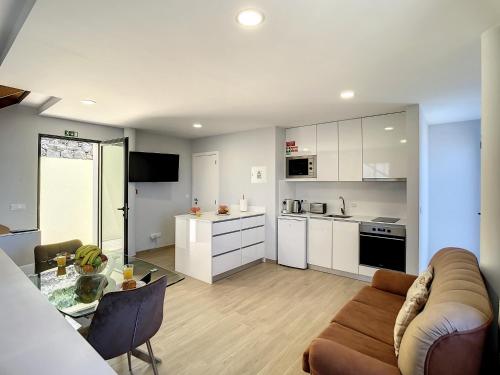 a living room and kitchen with a couch and a table at My School I by Atlantic Holiday in Ponta Delgada