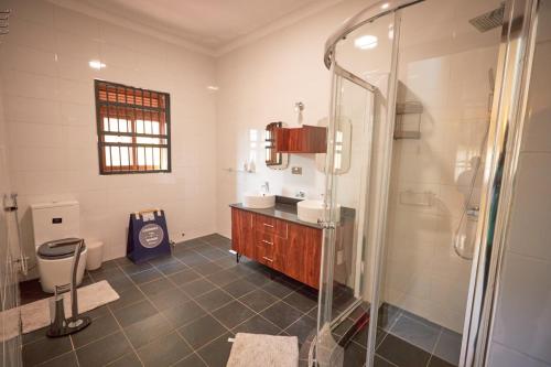 a bathroom with a shower and a sink and a toilet at The Forest House - Kawuku-Bunga in Kampala