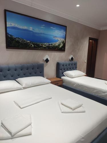 Cette chambre dispose de 2 lits et d'une télévision murale. dans l'établissement Hotel Salvadore, à Vlorë