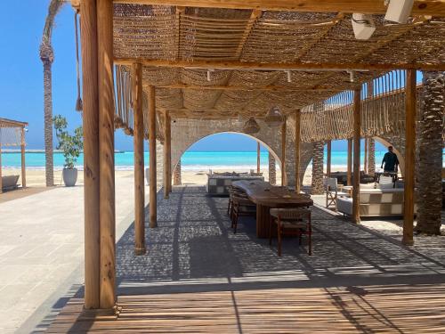 un pabellón en la playa con mesa y sillas en MARASSI Marina west ll 1BR 3BD near of SOL beach en El Alamein