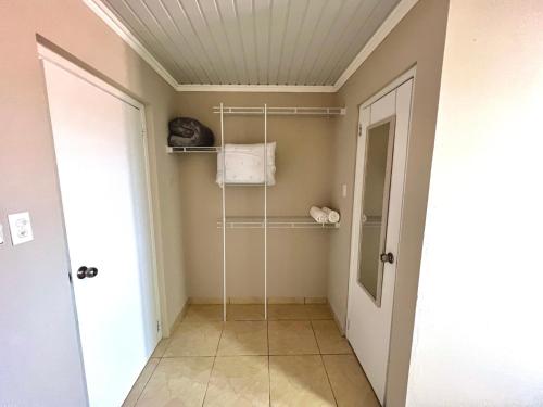 a bathroom with a walk in shower and a door at The Gold Vacation Apartments in Santa Cruz