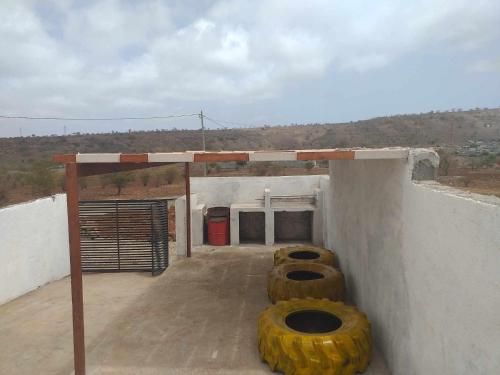 three large tires sitting on the side of a building at Casa de Campo GONZÁLEZ in Pedra Badejo
