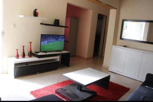 a living room with a television and a table at Casa de Campo GONZÁLEZ in Pedra Badejo