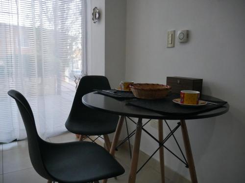 una mesa con dos sillas y un tazón de comida. en Habitación Privada en Edificio de Departamentos en Salta