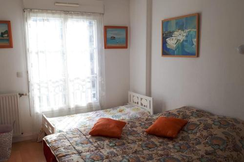 ein Schlafzimmer mit einem Bett mit zwei Kissen darauf in der Unterkunft Appartement 65m2/2piéces/centre/parking privé in Bordeaux