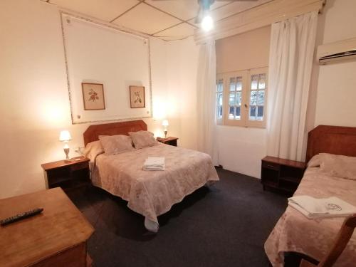 Habitación de hotel con 2 camas y mesa en Hotel Richmond, en Montevideo