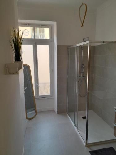 een badkamer met een glazen douche en een raam bij Cosy et splendide appartement ! in Nice