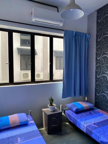 a room with two beds and a window at Marina Hostel in Ipoh