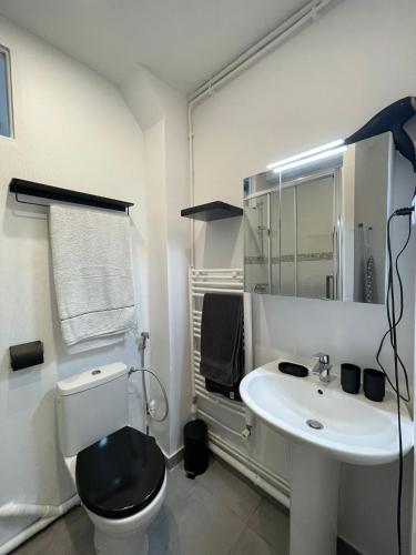 une salle de bain blanche avec des toilettes et un lavabo dans l'établissement Paris Eiffel Flats, à Paris