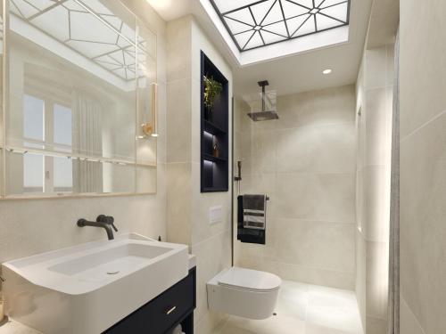 ein Badezimmer mit einem Waschbecken, einem WC und einem Dachfenster in der Unterkunft Hive Luxury Suites Collection in Kotor