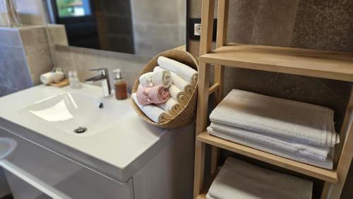 ein Bad mit einem Waschbecken und einem Korb mit Handtüchern in der Unterkunft Eximius Apartment in Pula