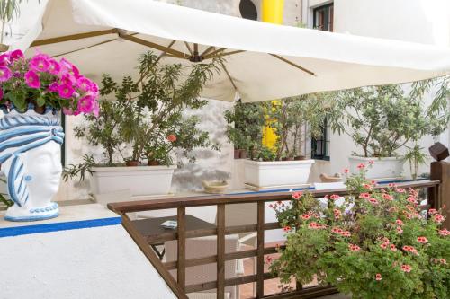 a table with a white umbrella and potted plants at Centrale in Trapani