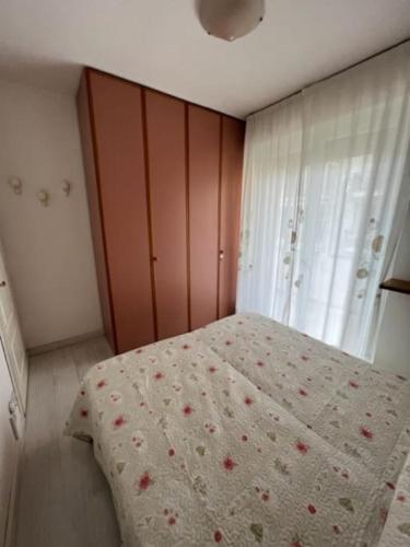 a bedroom with a bed with a floral bedspread at A cà di nonni in Albenga