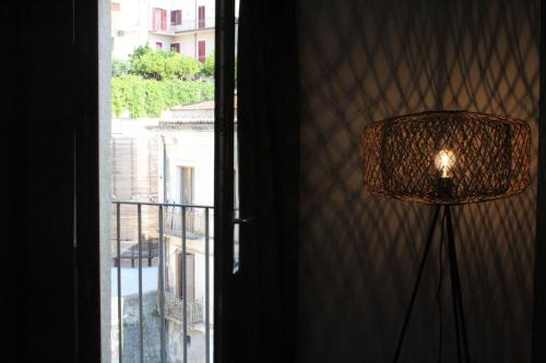 a lamp in front of a window with a view at Dimora 7 fontane in Paola