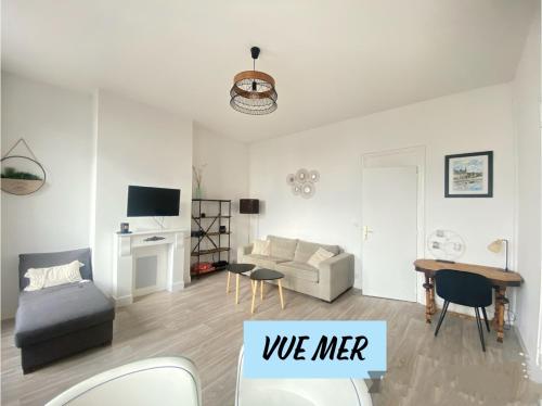 uma sala de estar com um sofá e uma mesa em Le Rayon Vert vue mer em Fécamp