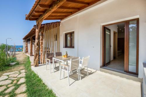 a patio with a table and chairs next to a building at Oasis Deluxe Studios in Pefkari