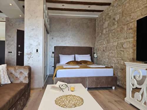 a hotel room with a bed and a couch at Luxury Seafront Suite Fabri in Vis