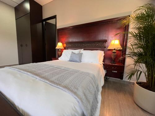 グアタペにある1714 Hotel Boutique Guatapéのベッドルーム(大きな白いベッド1台、植物付)