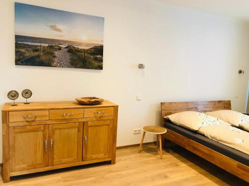 1 dormitorio con cama y tocador de madera en Ferienbungalow mit Terrasse - Familie Kader, en Eckernförde