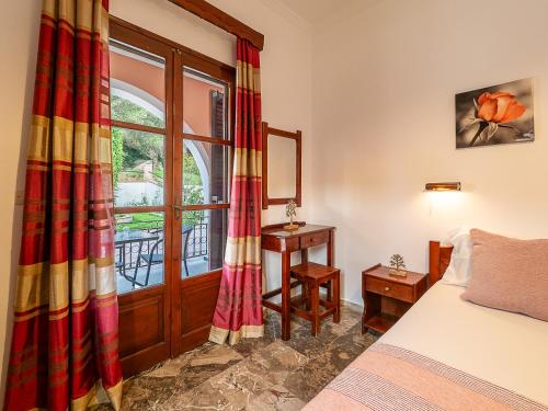 um quarto com uma cama e uma grande janela em XENOFONTAS APARTMENTs em Agios Georgios Pagon