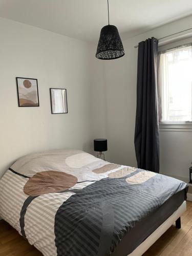 - une chambre avec un lit et une lampe pendant dans l'établissement Le Cosy, à Blois