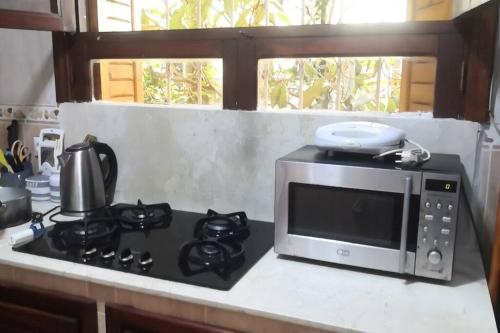 un horno microondas sobre una estufa en Casa Mima, en Tetuán