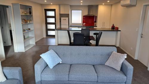a living room with a couch and a kitchen at South City Accommodation unit 4 in Invercargill